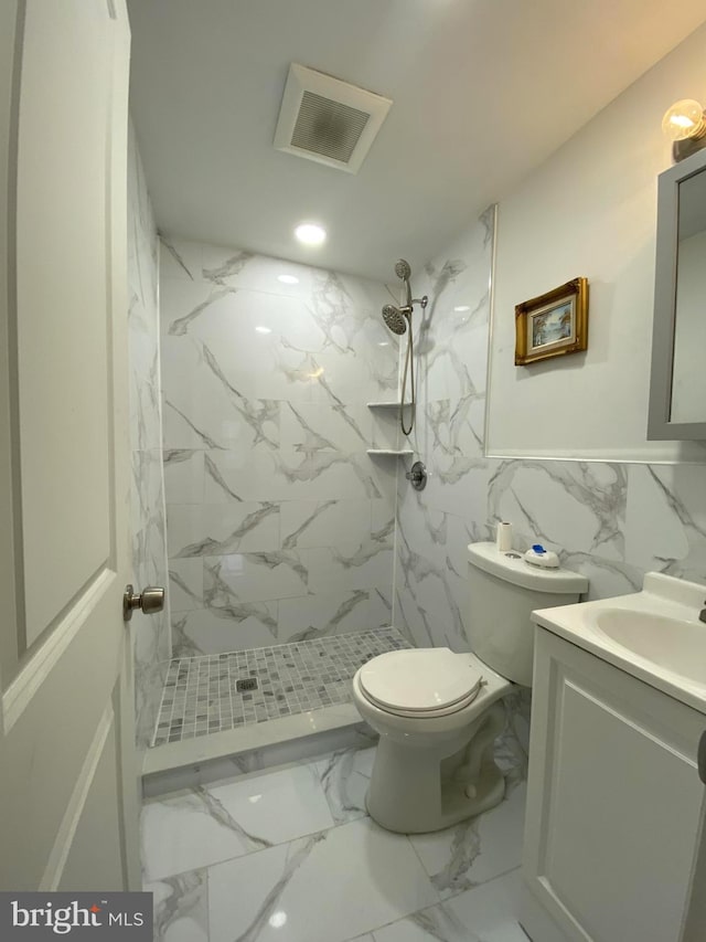 bathroom featuring vanity, toilet, and a tile shower