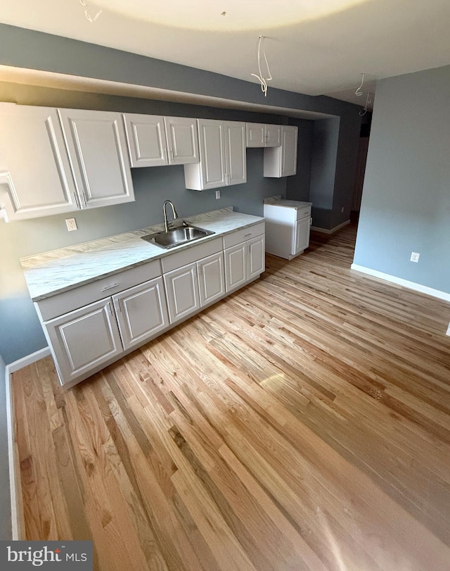 kitchen with sink and light hardwood / wood-style flooring