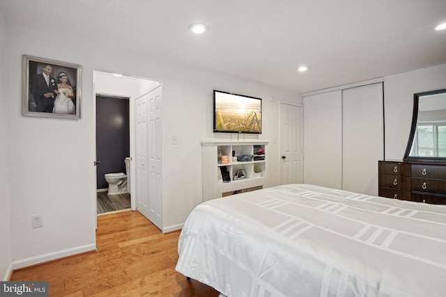 bedroom with ensuite bathroom and light hardwood / wood-style floors