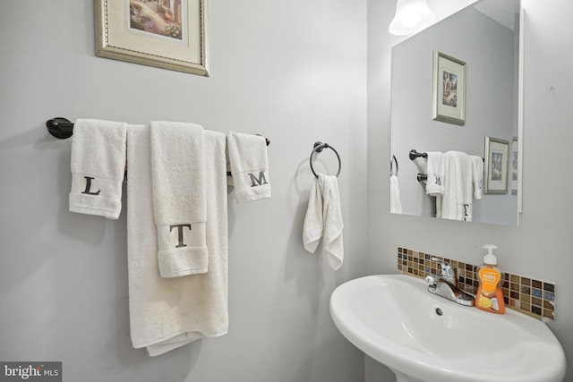 bathroom with decorative backsplash and sink