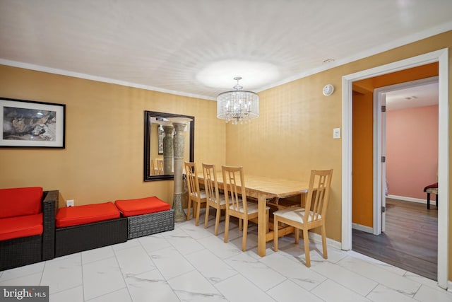 dining room featuring light hardwood / wood-style flooring, ornamental molding, and a notable chandelier