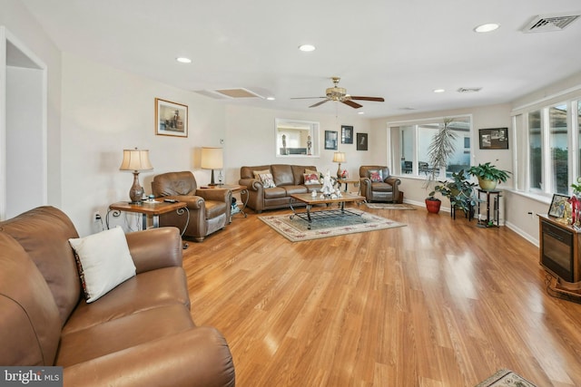 living room featuring light hardwood / wood-style floors and ceiling fan