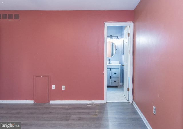 spare room featuring wood-type flooring and sink