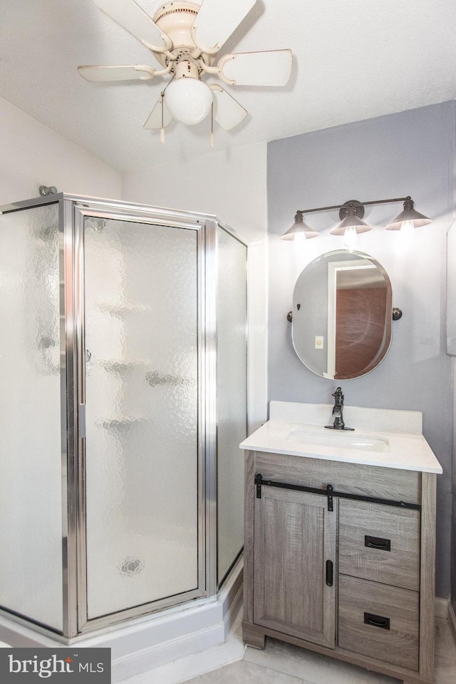 bathroom featuring ceiling fan, an enclosed shower, and vanity