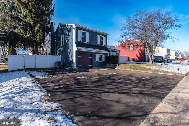 view of property featuring a garage and central AC