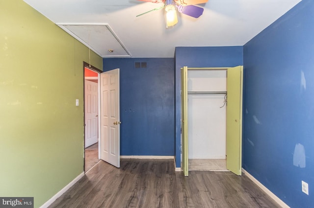 unfurnished bedroom featuring ceiling fan, dark hardwood / wood-style floors, and a closet