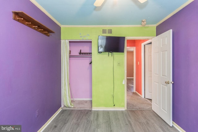 unfurnished bedroom featuring light hardwood / wood-style flooring, ceiling fan, and ornamental molding