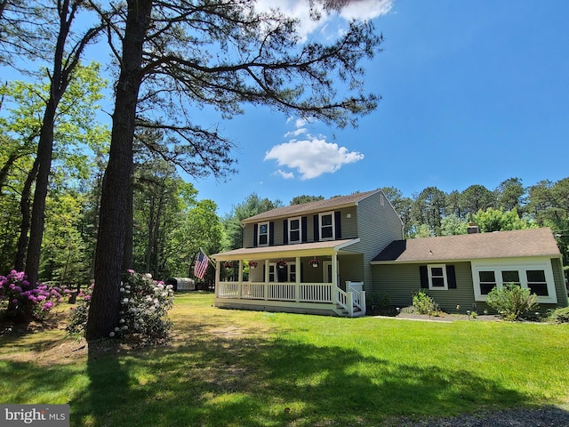 rear view of property with a yard and a porch