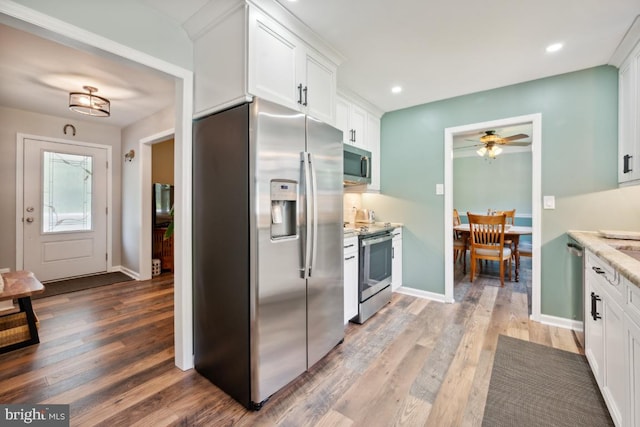 kitchen featuring white cabinets, stainless steel appliances, dark hardwood / wood-style floors, and ceiling fan