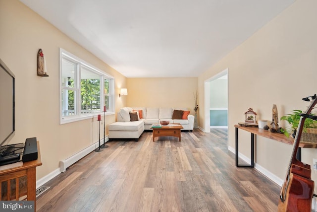 living room with hardwood / wood-style floors and a baseboard heating unit