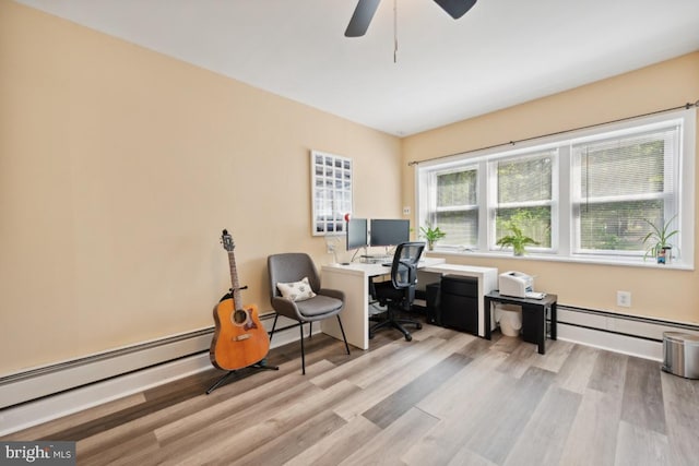 office space with light wood-type flooring, baseboard heating, and ceiling fan