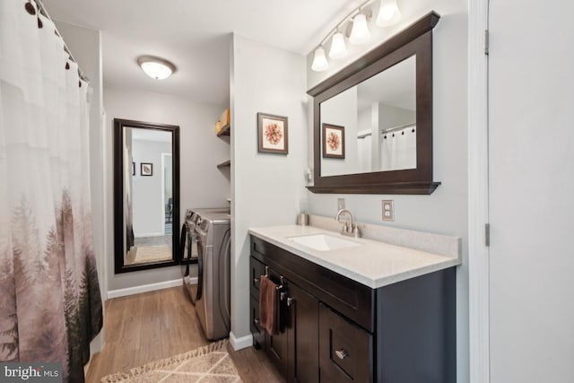 bathroom featuring separate washer and dryer, vanity, and hardwood / wood-style flooring