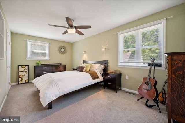 carpeted bedroom featuring multiple windows and ceiling fan