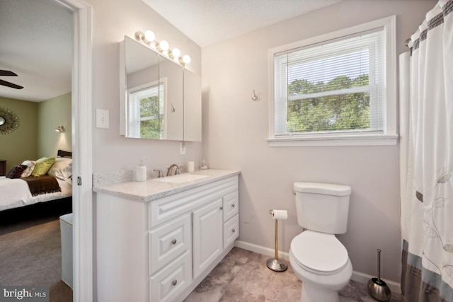 bathroom with plenty of natural light, ceiling fan, toilet, and vanity