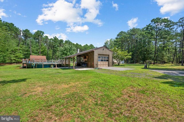 view of yard with a garage and an outbuilding