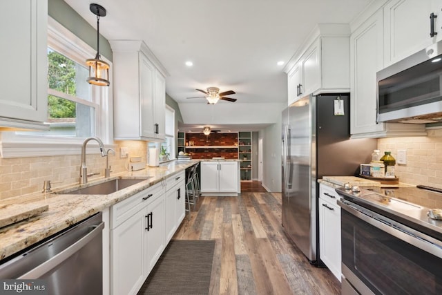 kitchen featuring backsplash, sink, white cabinetry, and stainless steel appliances