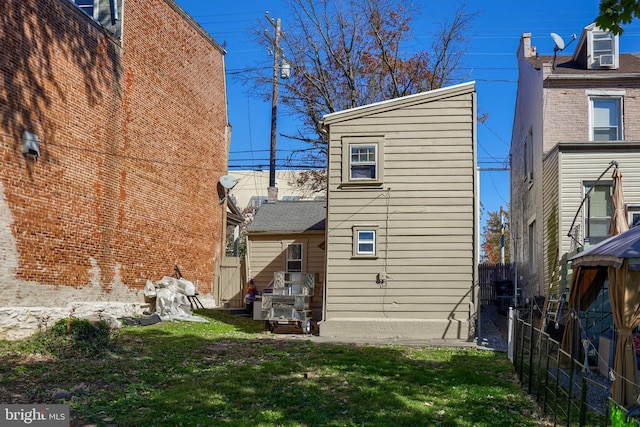 rear view of property featuring a lawn