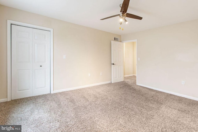 unfurnished bedroom with carpet, ceiling fan, and a closet