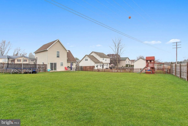 view of yard with a playground and a trampoline