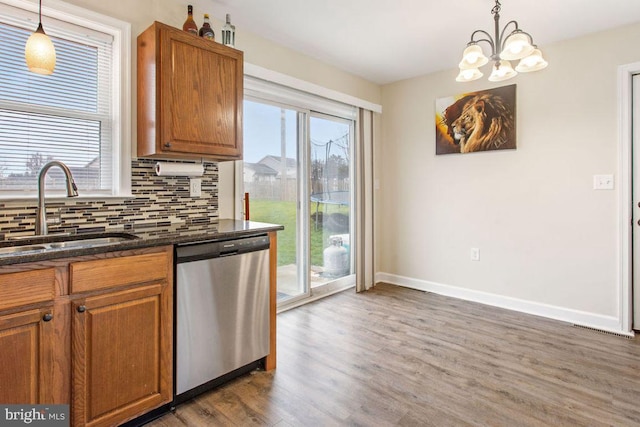 kitchen with stainless steel dishwasher, plenty of natural light, pendant lighting, and sink