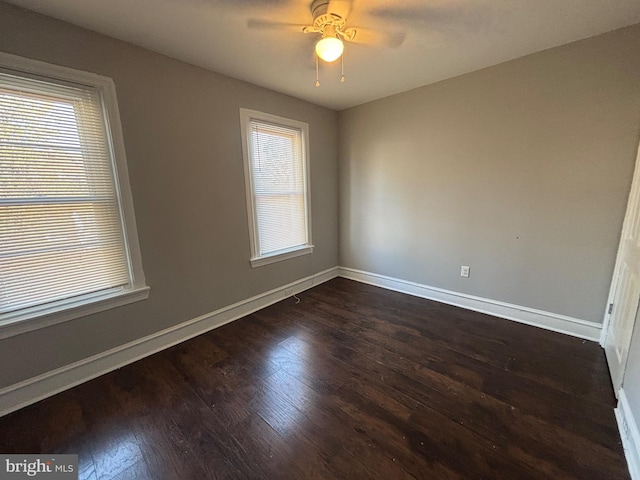 unfurnished room with ceiling fan and dark wood-type flooring