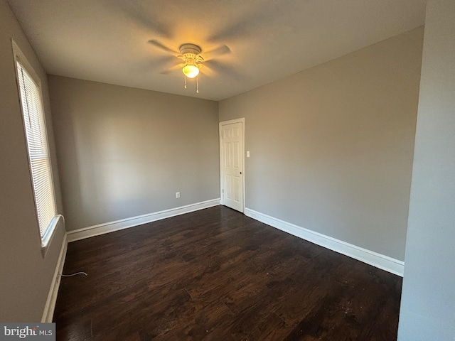 spare room with ceiling fan and dark wood-type flooring