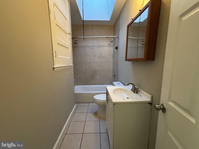 full bathroom featuring a skylight, tiled shower / bath combo, tile patterned floors, toilet, and vanity