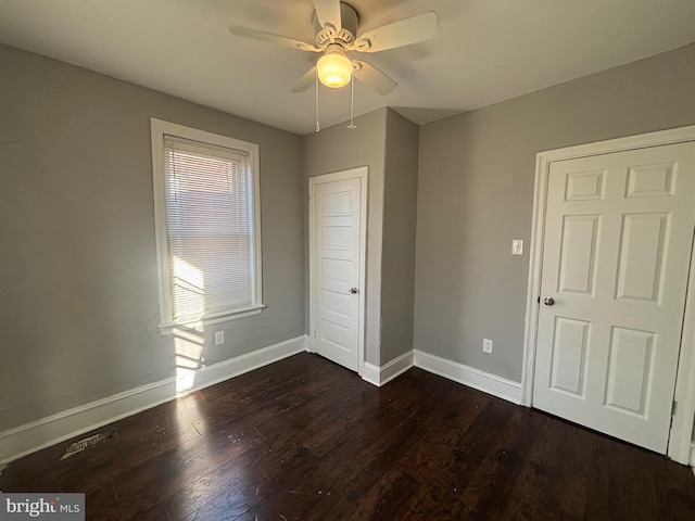 unfurnished bedroom with ceiling fan and dark hardwood / wood-style floors