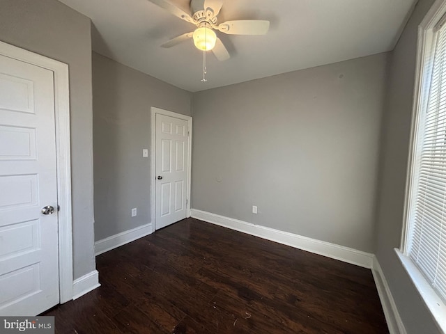 unfurnished bedroom with ceiling fan and dark hardwood / wood-style flooring