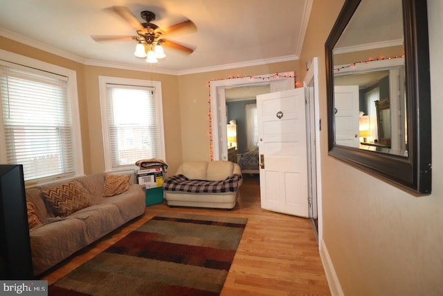 living room with light wood-type flooring, ceiling fan, and crown molding