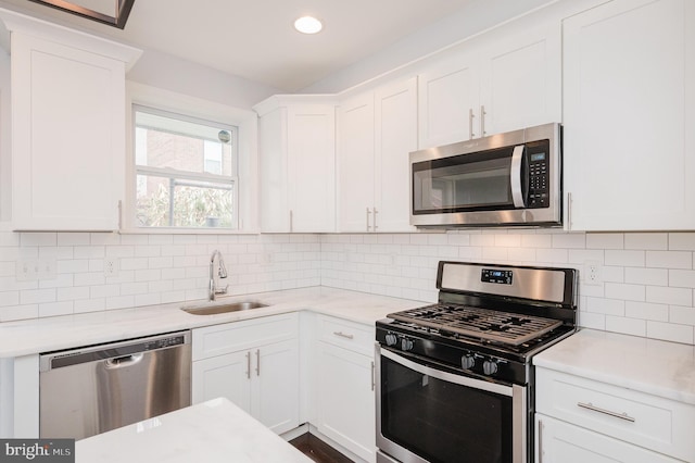 kitchen featuring white cabinets, decorative backsplash, sink, and appliances with stainless steel finishes