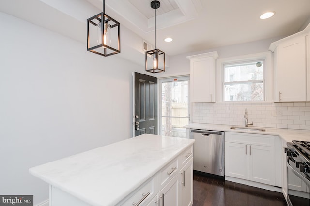 kitchen with white cabinets, appliances with stainless steel finishes, decorative light fixtures, and sink