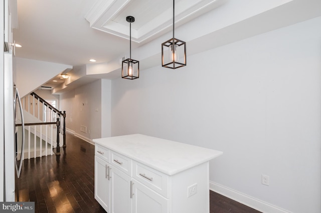 kitchen with white cabinets, a center island, hanging light fixtures, and dark wood-type flooring