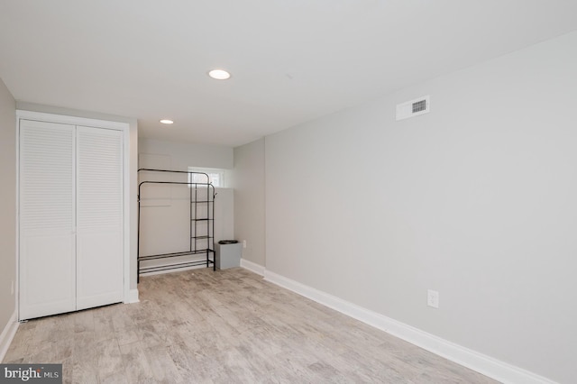 unfurnished bedroom with light wood-type flooring and a closet