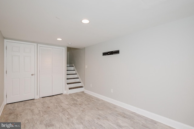 basement with light hardwood / wood-style flooring