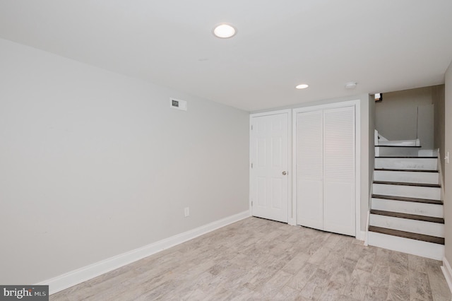 basement with light hardwood / wood-style floors