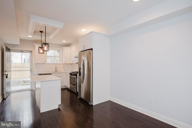 kitchen with white cabinets, a kitchen island, stainless steel appliances, and dark hardwood / wood-style floors