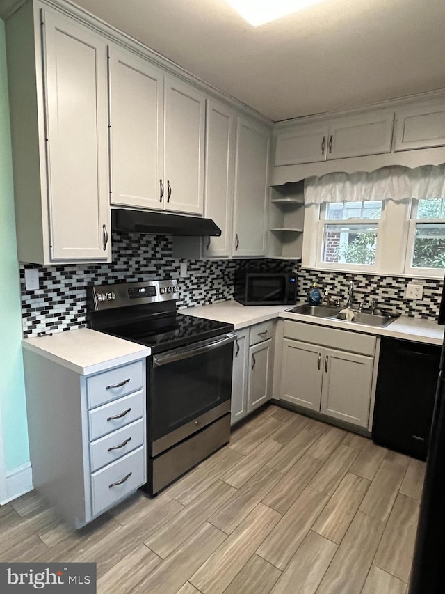 kitchen featuring black appliances, decorative backsplash, and sink