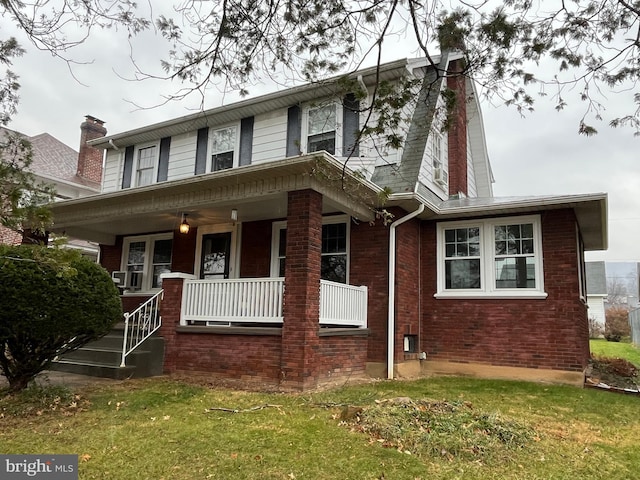 view of front of property with covered porch and a front yard