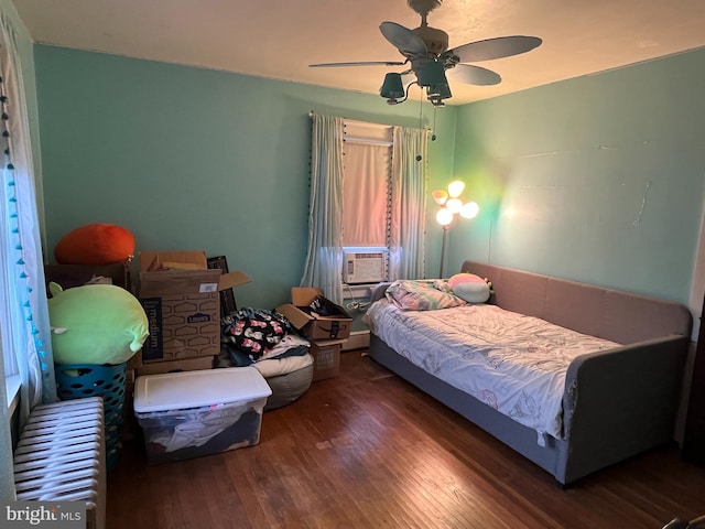 bedroom with dark hardwood / wood-style flooring, ceiling fan, and cooling unit