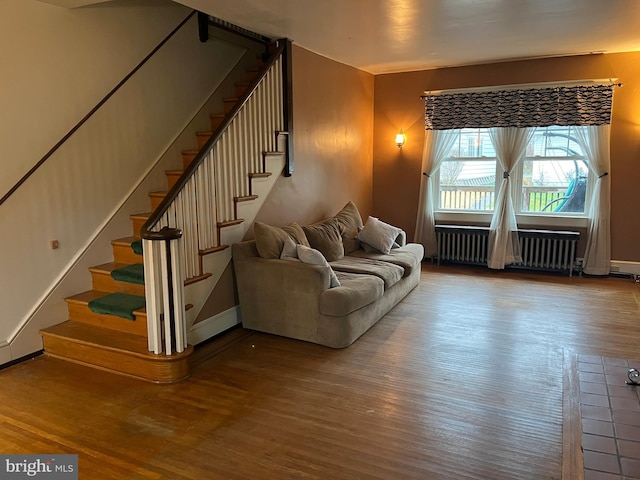 unfurnished living room with radiator heating unit and hardwood / wood-style floors