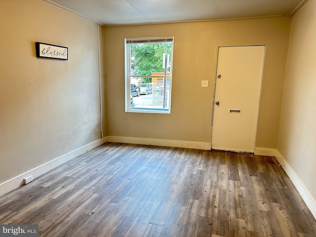 unfurnished room with wood-type flooring and ornamental molding