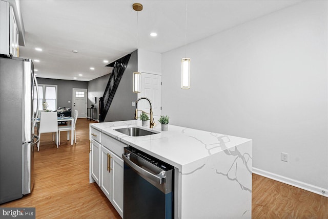 kitchen featuring a center island with sink, white cabinets, stainless steel appliances, and sink