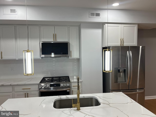 kitchen with light stone counters, stainless steel appliances, and tasteful backsplash