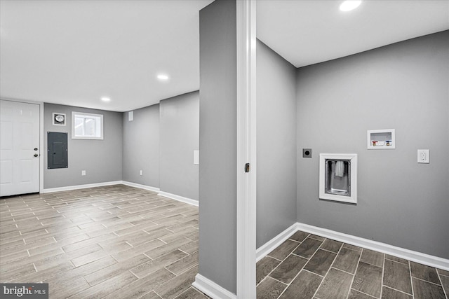 laundry area with hookup for an electric dryer, electric panel, light wood-type flooring, and hookup for a washing machine