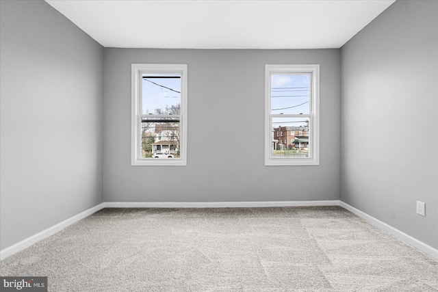 carpeted empty room featuring a wealth of natural light