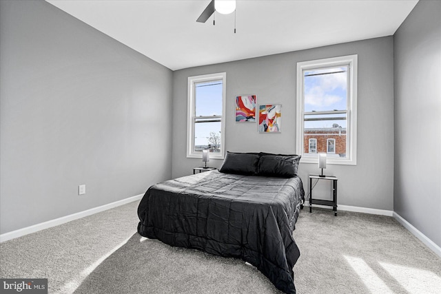 carpeted bedroom with multiple windows and ceiling fan