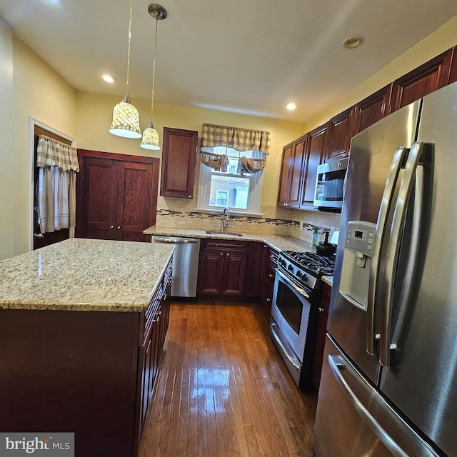 kitchen featuring sink, a center island, stainless steel appliances, dark hardwood / wood-style flooring, and pendant lighting