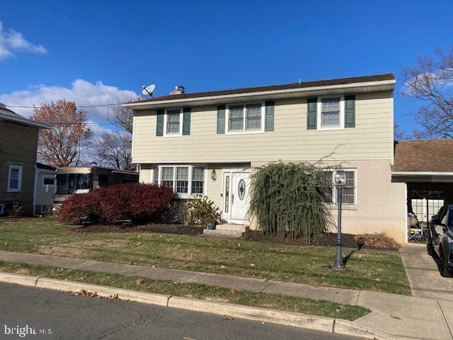 front facade with a front yard and a carport