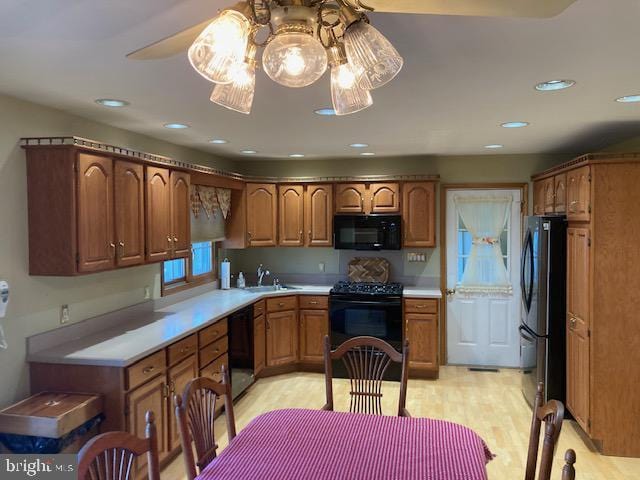 kitchen featuring black appliances, ceiling fan, and light hardwood / wood-style flooring